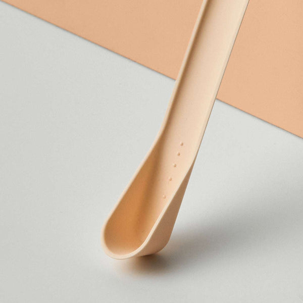 Beiger GAL Messlöffel aus Kunststoff, minimalistisches Design, auf hellem Hintergrund platziert. Löffel zeigt Vertiefungen.